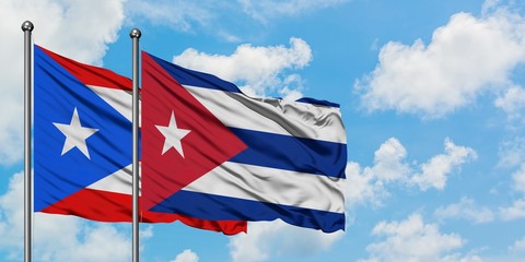 Puerto Rico and Cuba flag waving in the wind against white cloudy blue sky together. Diplomacy concept, international relations.