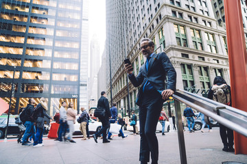 Businessman in crowded street with smartphone in hand