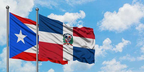 Puerto Rico and Dominican Republic flag waving in the wind against white cloudy blue sky together. Diplomacy concept, international relations.