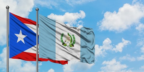 Puerto Rico and Guatemala flag waving in the wind against white cloudy blue sky together. Diplomacy concept, international relations.