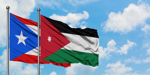 Puerto Rico and Jordan flag waving in the wind against white cloudy blue sky together. Diplomacy concept, international relations.