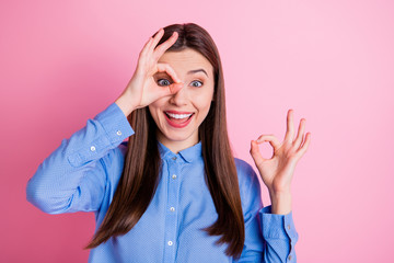 Close up photo of pretty lady showing okey symbol near eye approving good vision after using medical drops wear blue dotted shirt isolated pink color background