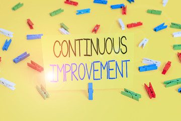 Text sign showing Continuous Improvement. Business photo text ongoing effort to improve products or processes Colored clothespin papers empty reminder yellow floor background office