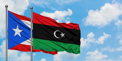 Puerto Rico and Libya flag waving in the wind against white cloudy blue sky together. Diplomacy concept, international relations.