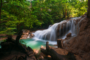 Waterfalls and fish swim in the emerald blue water in Erawan National Park. Erawan Waterfall is a beautiful natural rock waterfall in Kanchanaburi, Thailand.Onsen atmosphere.