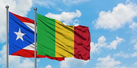 Puerto Rico and Mali flag waving in the wind against white cloudy blue sky together. Diplomacy concept, international relations.