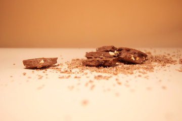 Pieces of chocolate on a background of fine chips. Side view