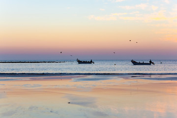 Two fishing boats against the sunset