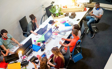 Young co-workers team talking during startup - Happy people planning a new project in creative...