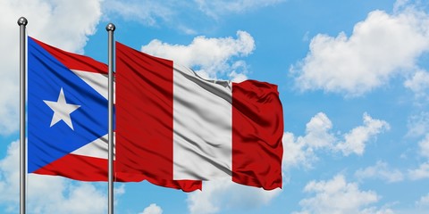 Puerto Rico and Peru flag waving in the wind against white cloudy blue sky together. Diplomacy concept, international relations.