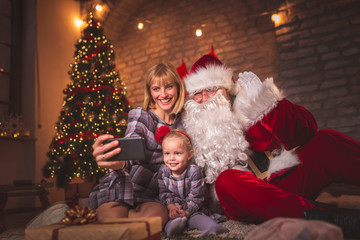 Mother and daughter taking a selfie with Santa