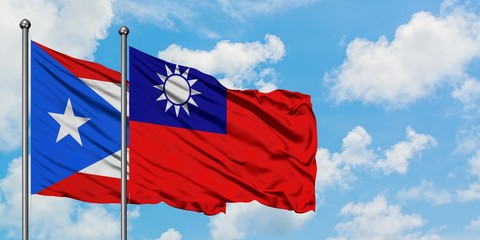 Puerto Rico and Taiwan flag waving in the wind against white cloudy blue sky together. Diplomacy concept, international relations.