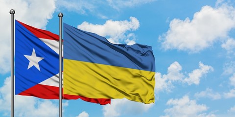 Puerto Rico and Ukraine flag waving in the wind against white cloudy blue sky together. Diplomacy concept, international relations.