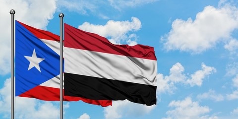 Puerto Rico and Yemen flag waving in the wind against white cloudy blue sky together. Diplomacy concept, international relations.