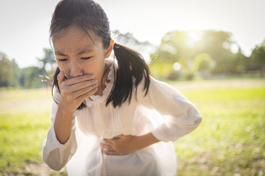 Asian Beautiful Child Girl Covered Her Mouth About To Throw Up,vomit,puke Retch Barf,female Teenage Feel Sick From Indigestion Or Food Poisoning,stomach Upset Virus In Sunny Day,health Care Concept