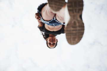 Woman in casual clothes stands on glass at daytime