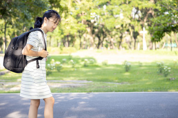 Asian child girl carrying heavy school bag or backpack,teenage feeling unhappy and pain on back, full of books on her back, going to school for the first time, tired student back to school learning
