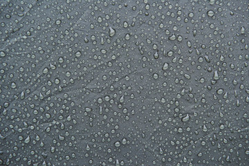 Wet grey surface of touristic tent. Drops of water