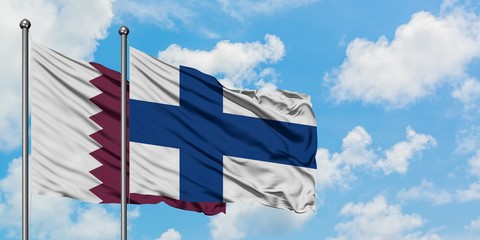 Qatar and Finland flag waving in the wind against white cloudy blue sky together. Diplomacy concept, international relations.