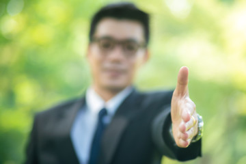 Handsome business man show blank hand in city park