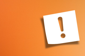 	 Note paper with exclamation mark on orange background	