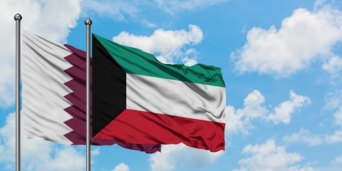Qatar and Kuwait flag waving in the wind against white cloudy blue sky together. Diplomacy concept, international relations.