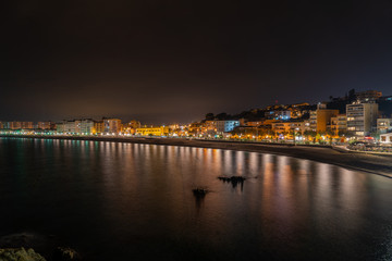 Blanes fotografia nocturna con vistas al mar y ciudad iluminada reflejos en el agua 