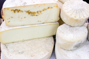 Various varieties of hard cheese on a wooden board. View from above.