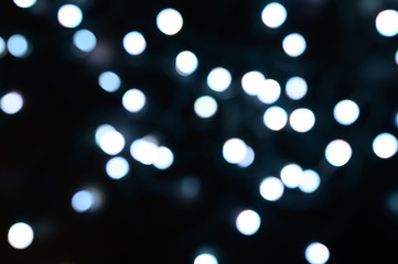 blurred night white glowing lights on black background. new year and christmas concept