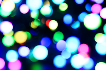 blurred night multicolored glowing lights on black background. new year and christmas concept