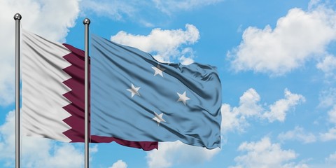 Qatar and Micronesia flag waving in the wind against white cloudy blue sky together. Diplomacy...