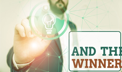 Writing note showing And The Winner Is. Business concept for announcing a demonstrating or thing that wins something Male human wear formal suit presenting using smart device