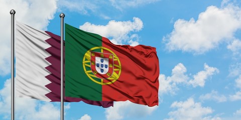 Qatar and Portugal flag waving in the wind against white cloudy blue sky together. Diplomacy concept, international relations.