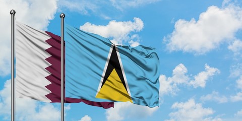Qatar and Saint Lucia flag waving in the wind against white cloudy blue sky together. Diplomacy concept, international relations.
