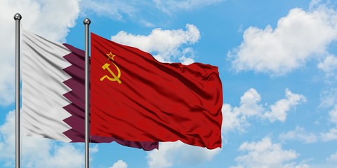 Qatar and Soviet Union flag waving in the wind against white cloudy blue sky together. Diplomacy concept, international relations.