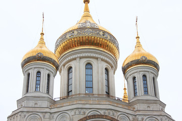 Russian orthodox church domes with golden cross. Religious symbols isolated on cloudy sky 