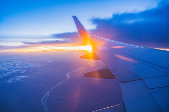 Beautiful sunset, sky on the top view, airplane flying view from inside window aircraft of Traveling.