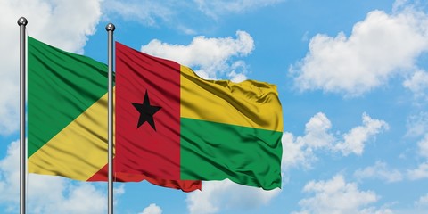 Republic Of The Congo and Guinea Bissau flag waving in the wind against white cloudy blue sky together. Diplomacy concept, international relations.
