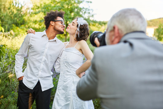 Wedding photographer photographs newlyweds kissing