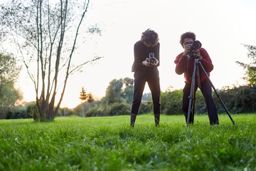 Photographer team on a meadow with camera and tripod