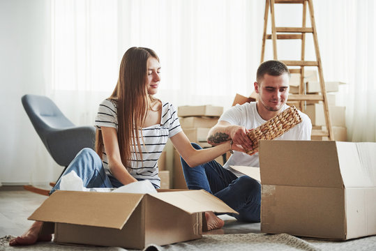Time to unpack those boxes. Cheerful young couple in their new apartment. Conception of moving