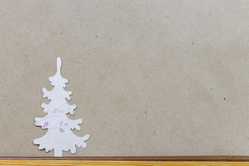 White Christmas tree made of paper on brown craft paper background