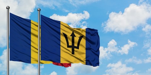 Romania and Barbados flag waving in the wind against white cloudy blue sky together. Diplomacy...