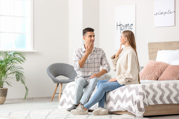 Young deaf mute couple using sign language at home