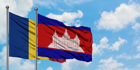 Romania and Cambodia flag waving in the wind against white cloudy blue sky together. Diplomacy...
