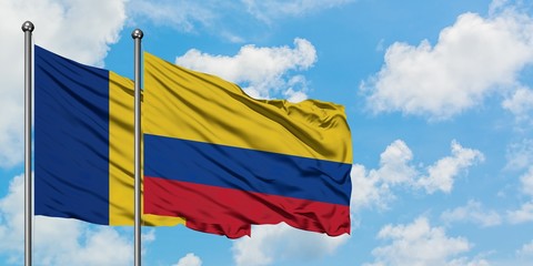 Romania and Colombia flag waving in the wind against white cloudy blue sky together. Diplomacy concept, international relations.