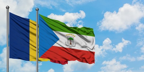 Romania and Equatorial Guinea flag waving in the wind against white cloudy blue sky together....