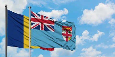 Romania and Fiji flag waving in the wind against white cloudy blue sky together. Diplomacy concept, international relations.