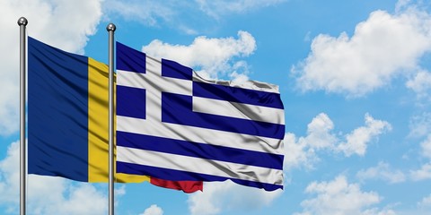 Romania and Greece flag waving in the wind against white cloudy blue sky together. Diplomacy concept, international relations.