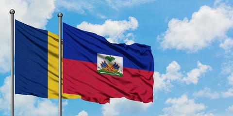 Romania and Haiti flag waving in the wind against white cloudy blue sky together. Diplomacy...